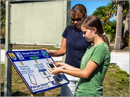 Visitors at Pelican Island National Wildlife Refuge in Florida scan QR code enabled signs to learn more. Credit: Vince Lamb. 