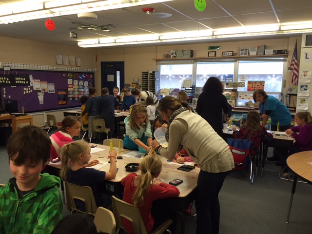 Graduate student help elementary students with soil experiment